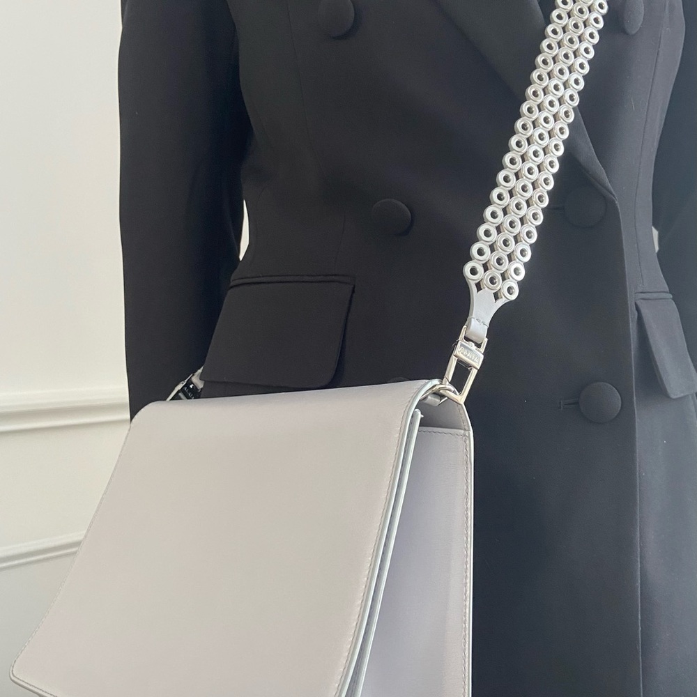 ALAÏA gray crossbody leather bag with silver grommet strap